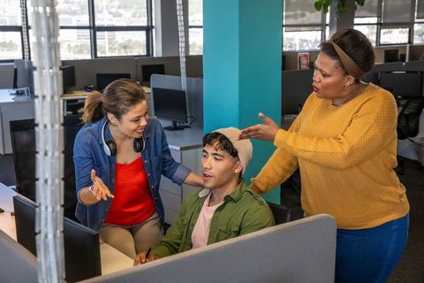 Young multicultural team collaborating in open-plan office during brainstorming session