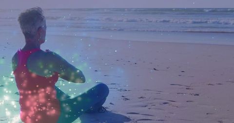 Senior Woman Meditating with Meditation Aura on Beach at Sunrise