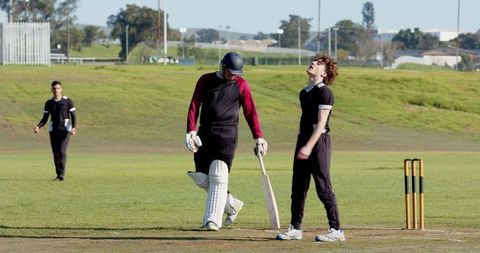Male Cricketers Prepared for Bowling an Intense Match Outdoors