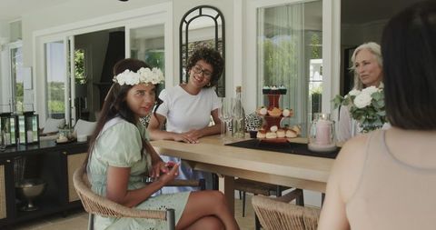 Women celebrate bridal shower with cupcakes and drinks at home