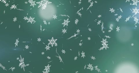 Falling snowflakes on green backdrop with light flare