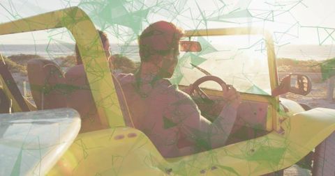 Driving yellow dune buggy along coastal dunes at sunset with surfboard and couple