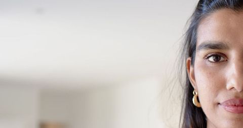 Elegant Woman Posing with Gold Earrings in Minimalist Home