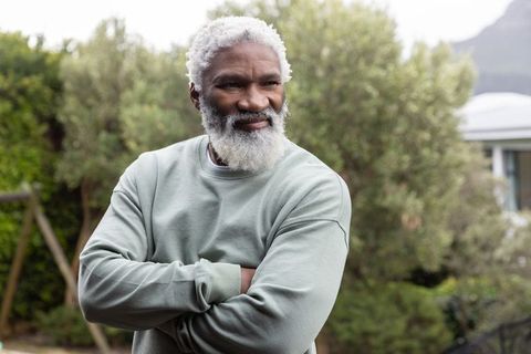 Senior african american man standing with arms crossed in garden calm outdoor portrait