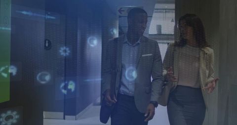 Walking professionals discussing augmented reality data overlay in modern office corridor