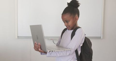 African American Girl Engaging with Laptop in Classroom Setting