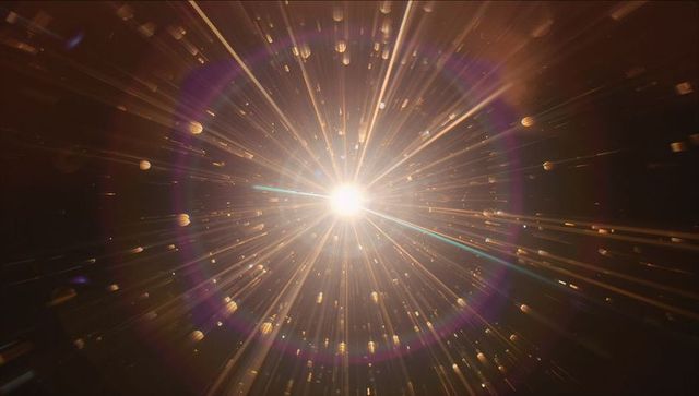 Radiating starburst spotlight casting golden beams with purple lens flare and floating particles
