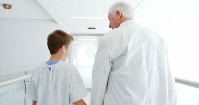 Senior Doctor Escorting Young Patient in Hospital Hallway - Download Free Stock Images Pikwizard.com