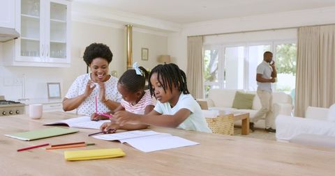 Mother Assisting Daughters with Homework at Cozy Home