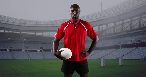 Rugby Player Posing Confidently in Stadium with Ball