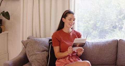 Woman Reading Booklet in Cozy Living Room Setting