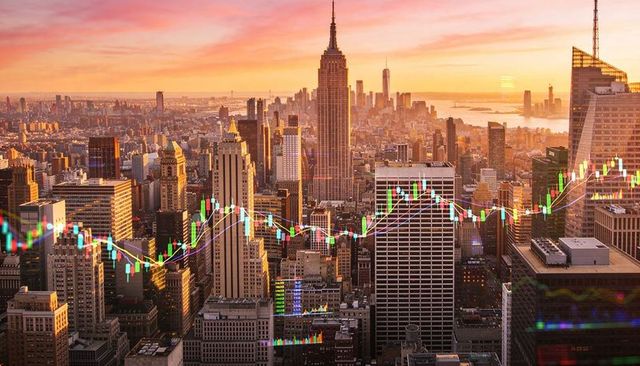 Empire state building glowing over new york skyline at sunset with market chart overlay