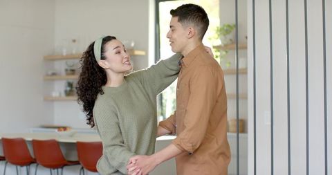 Cheerful Couple Dancing in Modern Home Kitchen