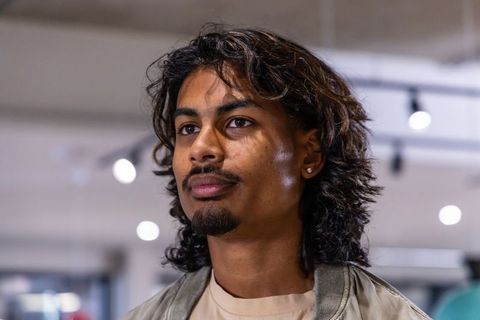 Indian man posing confident close-up portrait with stud earring and casual jacket
