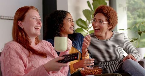 Diverse Group of Friends Relaxing at Home with Snacks