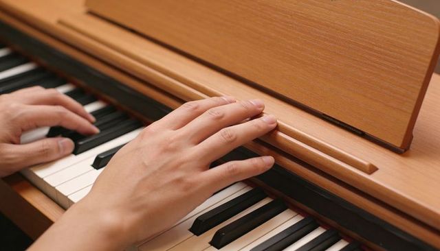 Hands playing piano keys on wooden upright piano close-up fingertip technique