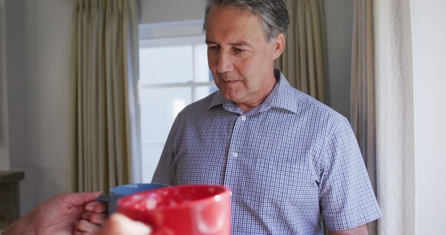 Mature man sharing hot beverages at home - Download Free Stock Images Pikwizard.com