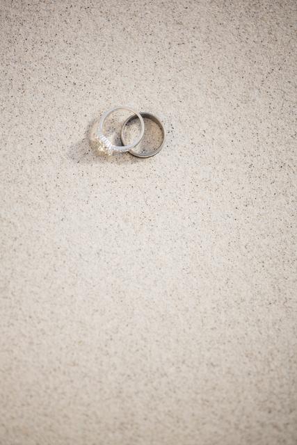 Pair of wedding ring on sand at beach
