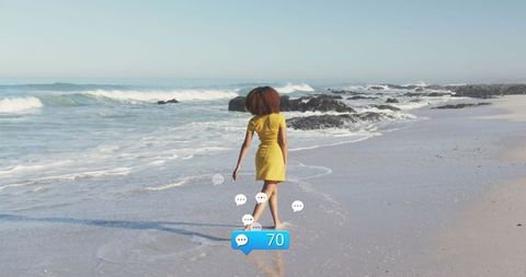 woman in yellow dress strolling by sea with digital interaction concept - Download Free Stock Images Pikwizard.com
