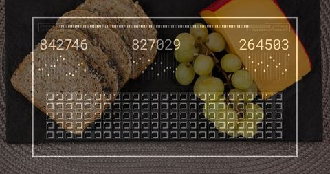 Displaying slate serving board with multigrain bread, green grapes, red-rind cheese and HUD overlay
