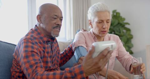 Senior couple monitoring blood pressure at home