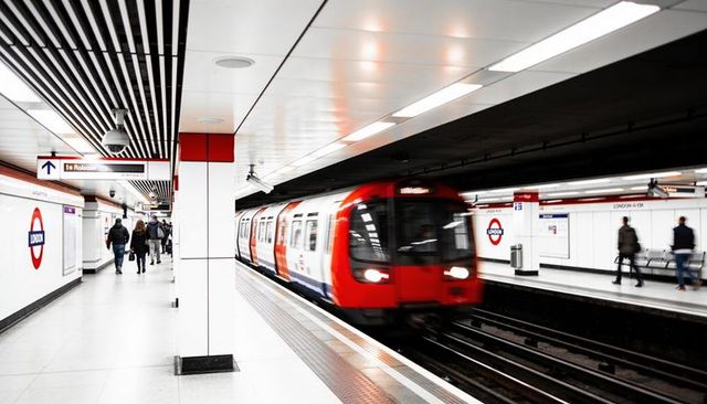 London underground train arriving at platform with commuters, motion blur, roundel signage