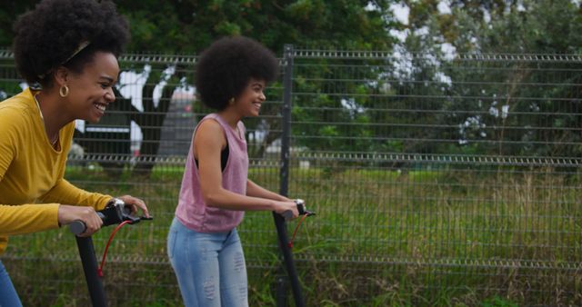 Two Young Women Enjoying Electric Scooter Ride Outdoors - Download Free Stock Images Pikwizard.com