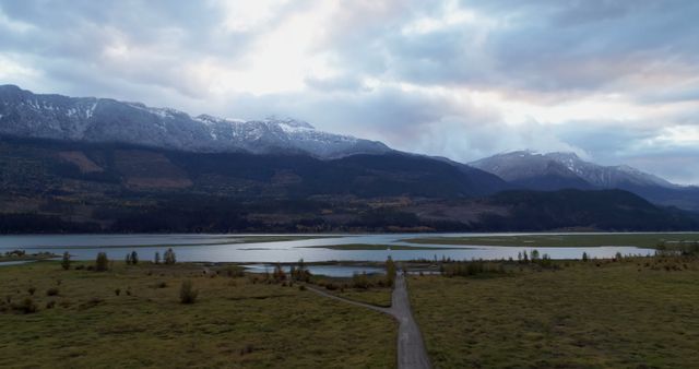 Scenic view of mountain ranges, lake and grassland during winter 4k