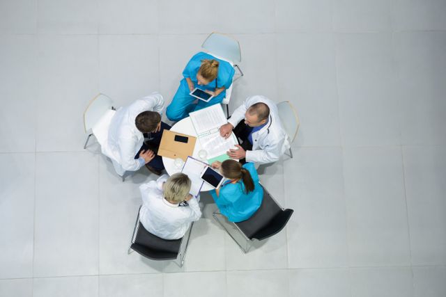 High angle view of doctors and surgeons interacting with each other in meeting at hospital