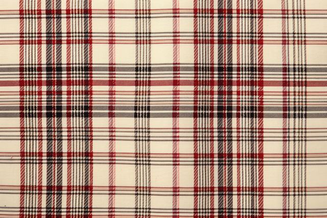Red and black plaid pattern on a beige background depicts classic tartan design. Ideal for fashion design, textile backgrounds, clothing materials, or digital backgrounds. It brings a traditional and classic touch to various creative projects, including graphic designs, print materials, and interior decor.