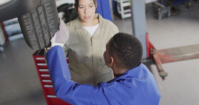 Auto Mechanic Discussing Tire Maintenance with Apprentice - Download Free Stock Images Pikwizard.com