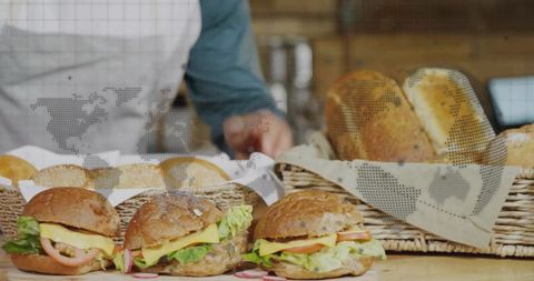 Baker preparing wholegrain sandwiches on rustic bakery counter with artisan bread baskets