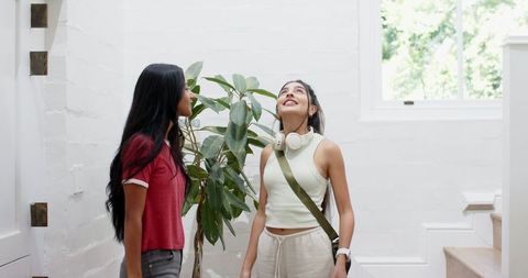 Friends Chatting Near Stairs in Bright Urban Interior
