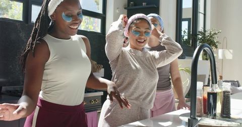 African american friends enjoying at-home skincare with gel eye patches and loungewear