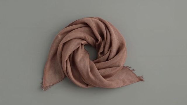 Elegant brown woven scarf on minimalist grey surface