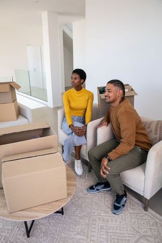 Couple unpacking boxes in modern minimalist living room