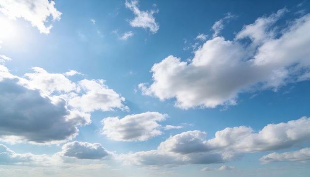 Sunlit cumulus clouds drifting across wide blue sky with soft cirrus wisps