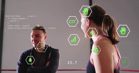Fitness coach coaching female athlete with augmented hud analytics in boxing ring training