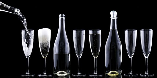 Pouring Champagne into Flutes with Bottles in Black Background - Download Free Stock Photos Pikwizard.com