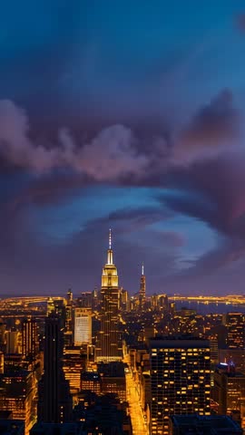 Vertical video framing Empire State Building at dusk with cloud ring forming over city skyline
