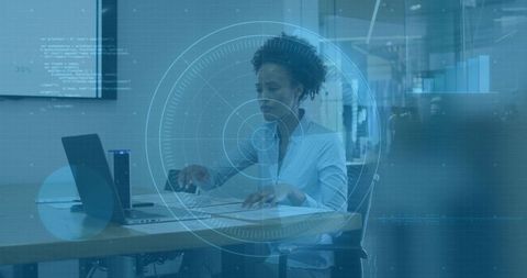 Professional woman reviewing documents and typing on laptop with ar hud data dashboard in office