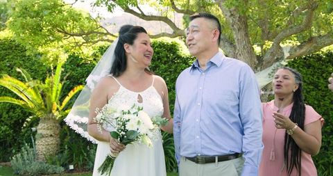 Happy Senior Couple With Friends at Outdoor Garden Wedding Celebration