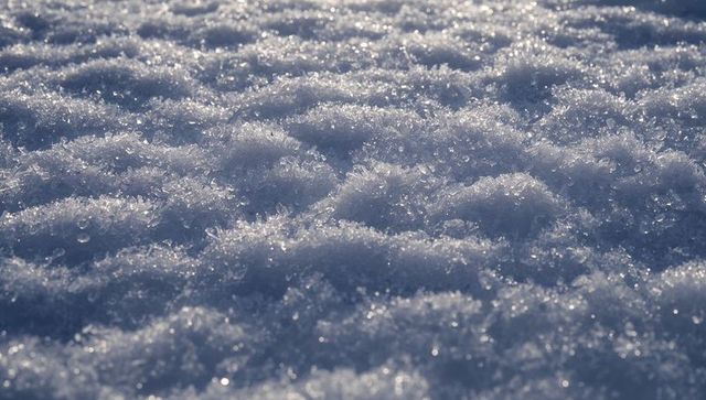 Glittering snow crystals close-up reflecting low sunlight on melting frost surface