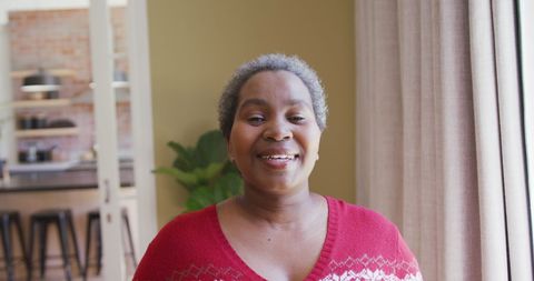 Smiling Woman in Festive Sweater at Home