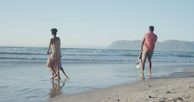 Family Enjoying Time Together Walking on Sandy Beach at Sunset - Download Free Stock Images Pikwizard.com