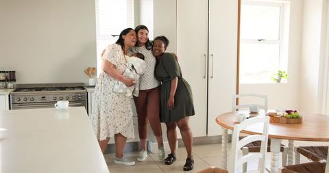 Diverse Friends Celebrating Engagement with Baby in Bright Kitchen