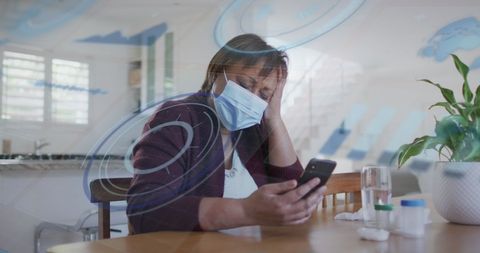 Stressed woman with mask using smartphone in modern home
