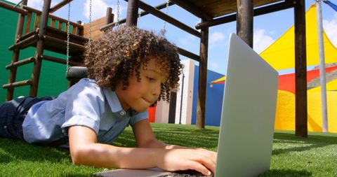 Young Boy Using Laptop at Playground Outdoors