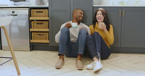 Happy Diverse Couple Relaxing with Coffee in Modern Kitchen