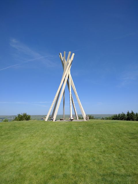 Tall Sculpture on Green Grassy Hill with Clear Blue Sky - Download Free Stock Images Pikwizard.com